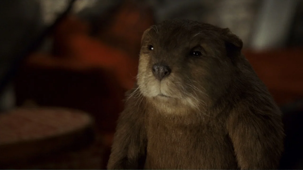 Epic Movie (2007) movie still: closeup — A dark indoor space contains a brown, furred beaver figure. The beaver sits facing slightly to the side…
