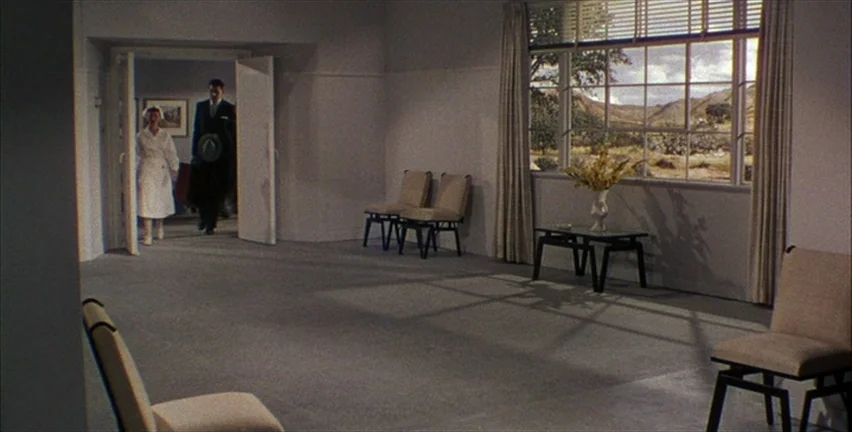 Magnificent Obsession (1954) movie still: wide — A spacious, minimalist waiting area with mid-century modern furniture and wide windows looking…