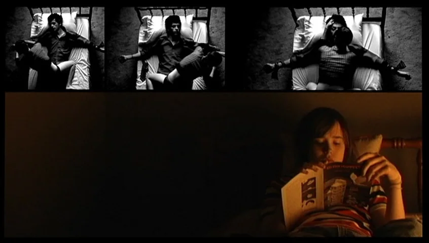 The Tracey Fragments (2007) movie still: medium — A dim bedroom at night with a person sitting in bed. The subject reads a small book by soft light…