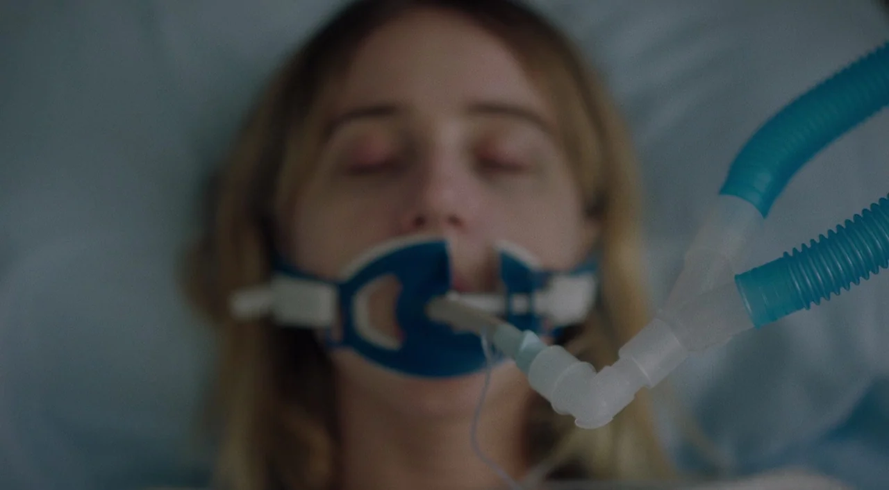 The Big Sick (2017) movie still: closeup — A medical setting featuring a patient lying on a pillow. A plastic ventilator mask is attached to the…