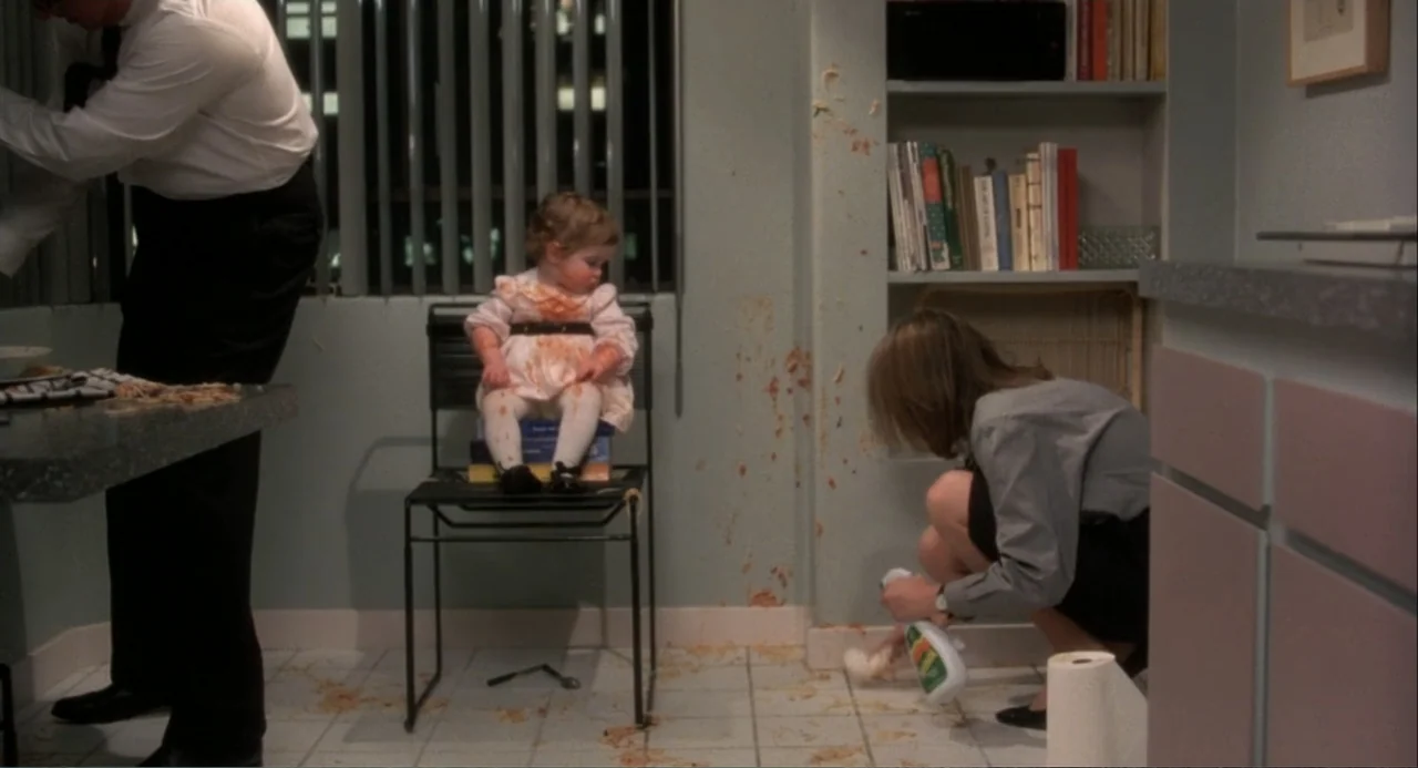 Baby Boom (1987) movie still: medium — A domestic room features light blue walls covered in splattered food and stained floor tiles. A young woman…
