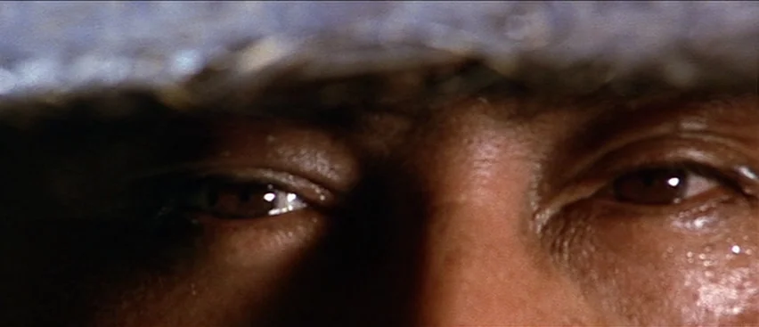 Lone Wolf and Cub: Baby Cart to Hades (1972) movie still: closeup — Close up of a man's eyes partially obscured by a heavy hat brim. Sweat beads on…