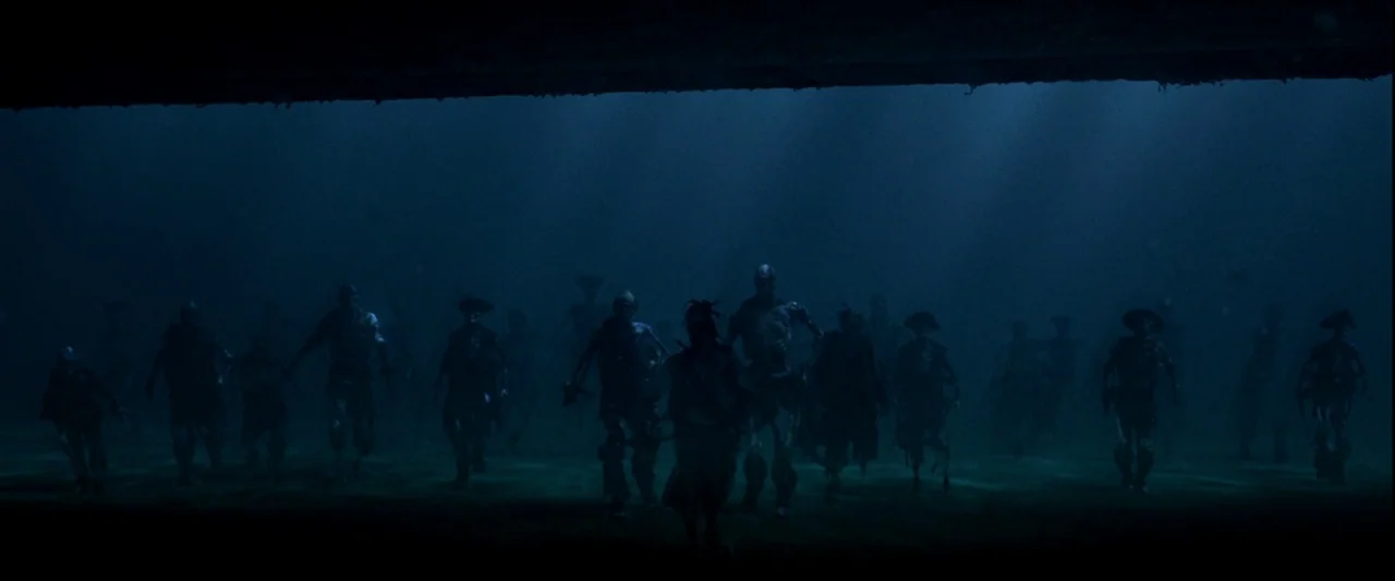 Pirates of the Caribbean: The Curse of the Black Pearl movie still: wide — A dark, submerged seafloor is populated by a crowd of skeletal, seafaring…