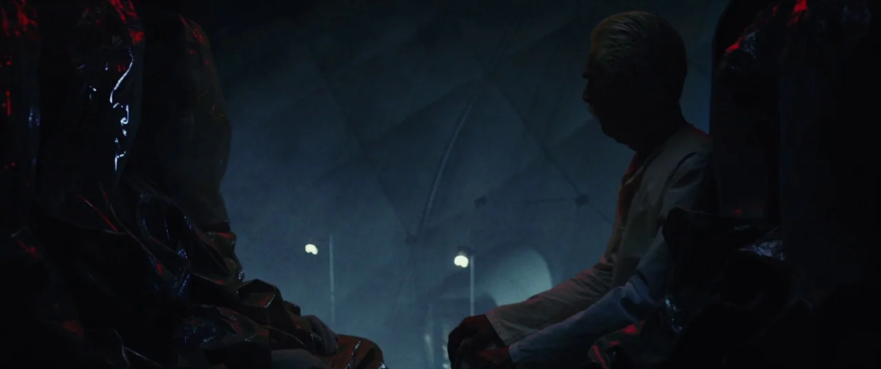 The Man Who Killed Hitler and Then the Bigfoot (2018) movie still: medium — An industrial cargo hold features geometric wall panels and dim overhead…