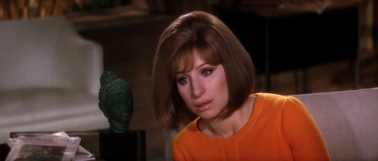 On A Clear Day You Can See Forever (1970) movie still: medium — A mid-century modern living room features a small green bust on a table. A woman…