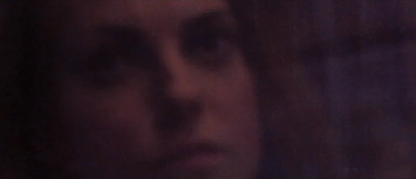 This Movie Is Broken (2010) movie still: closeup — A dark indoor space with minimal ambient illumination covering the subject's face. The person…