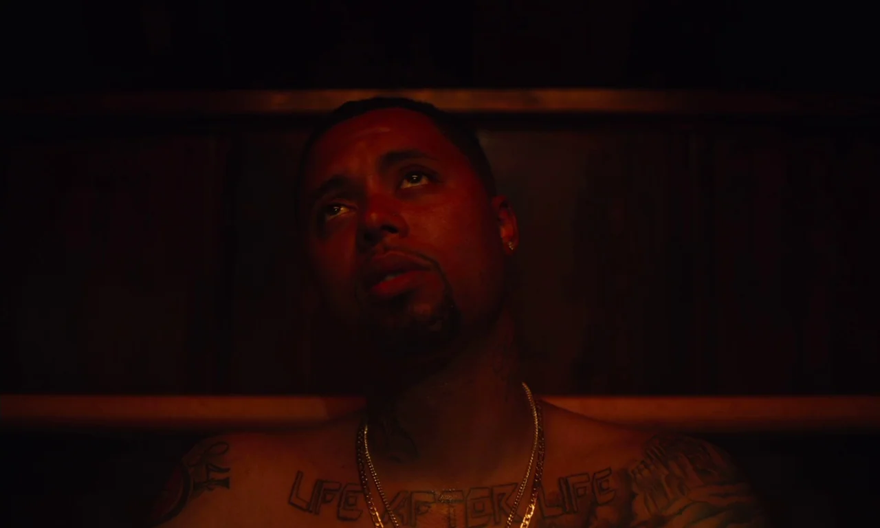 The Last Black Man in San Francisco (2019) movie still: closeup — A dark wooden interior with horizontal slat walls typical of a sauna. A shirtless…