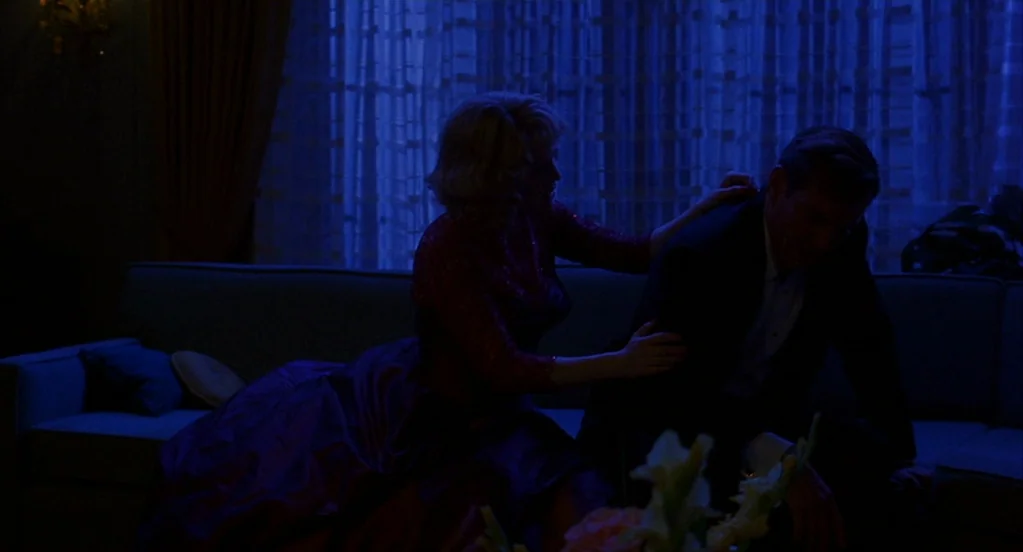 Far From Heaven (2002) movie still: medium — A dark room is illuminated only by blue light streaming through patterned curtains. A woman sits on a…