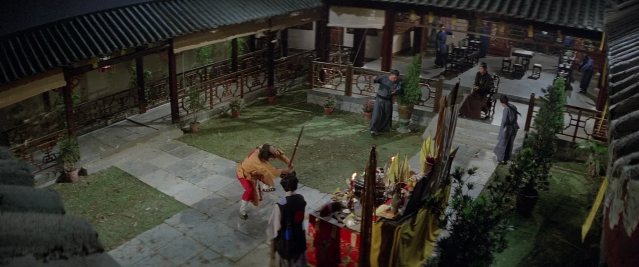 Encounter of the Spooky Kind (1980) movie still: wide — A traditional stone-paved courtyard is surrounded by roofed wooden walkways and decorative…