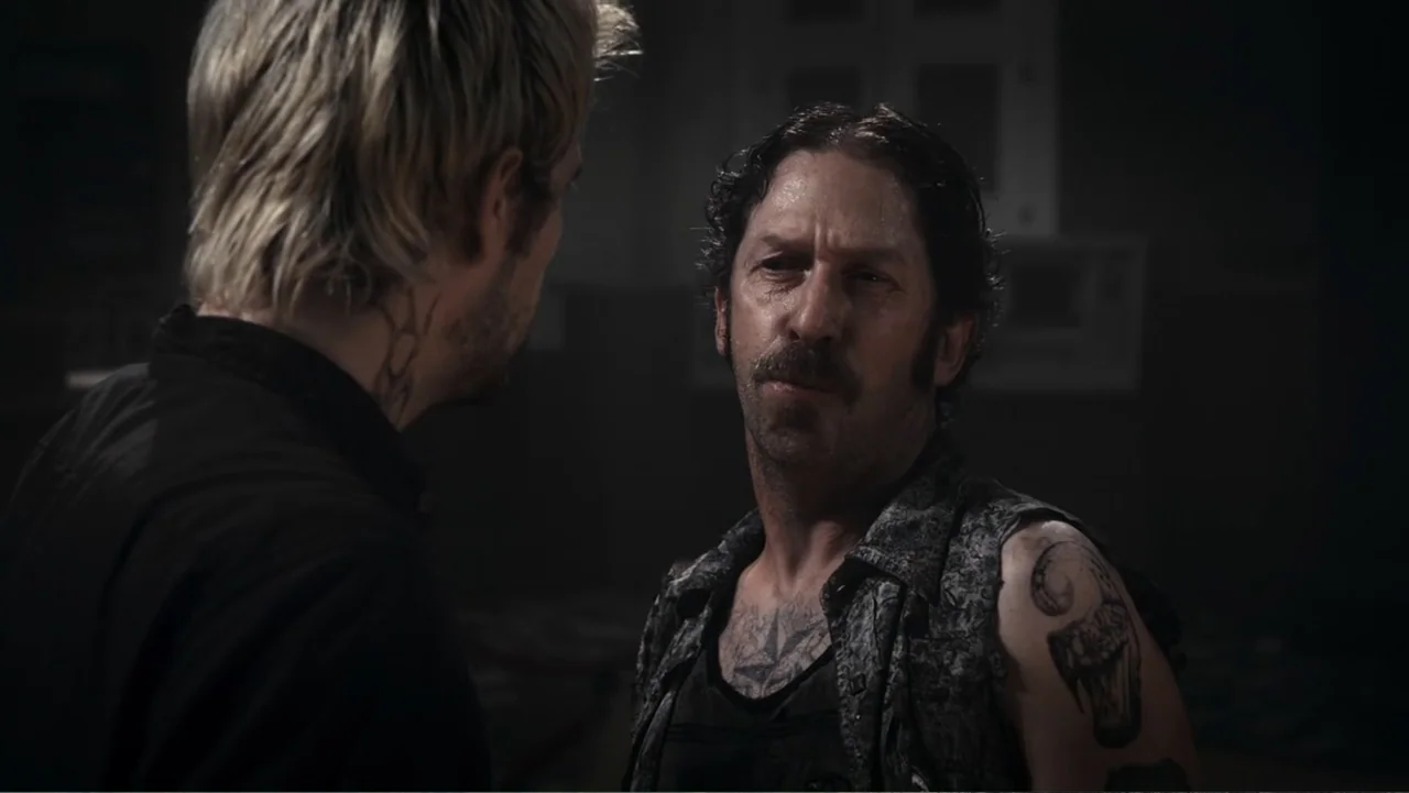 Flypaper (1999) movie still: medium — A dimly lit industrial room contains two men engaged in a serious conversation. The man on the right has…