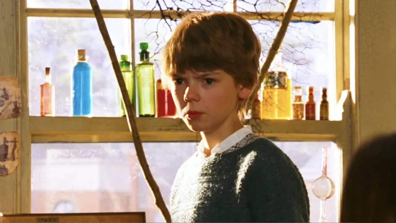 Nanny McPhee and the Big Bang (2010) movie still: medium — An interior space features a wooden window frame lined with colorful glass apothecary…
