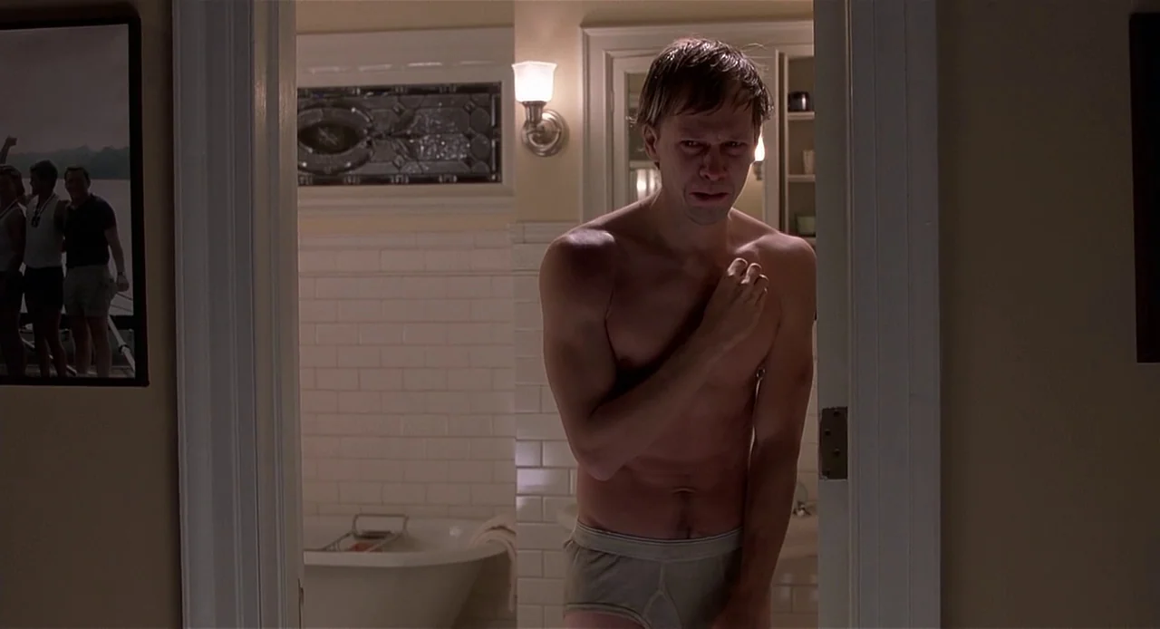 The Sixth Sense (1999) movie still: medium — A man in underwear stands in the doorway of a tiled washroom. He looks forward with a hand resting near…