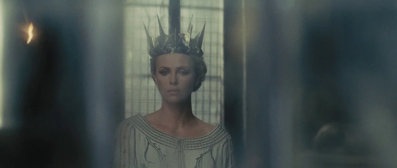 Snow White and The Huntsman (2012) movie still: medium — A stone-walled interior with a window featuring a grid frame behind the subject. A woman…