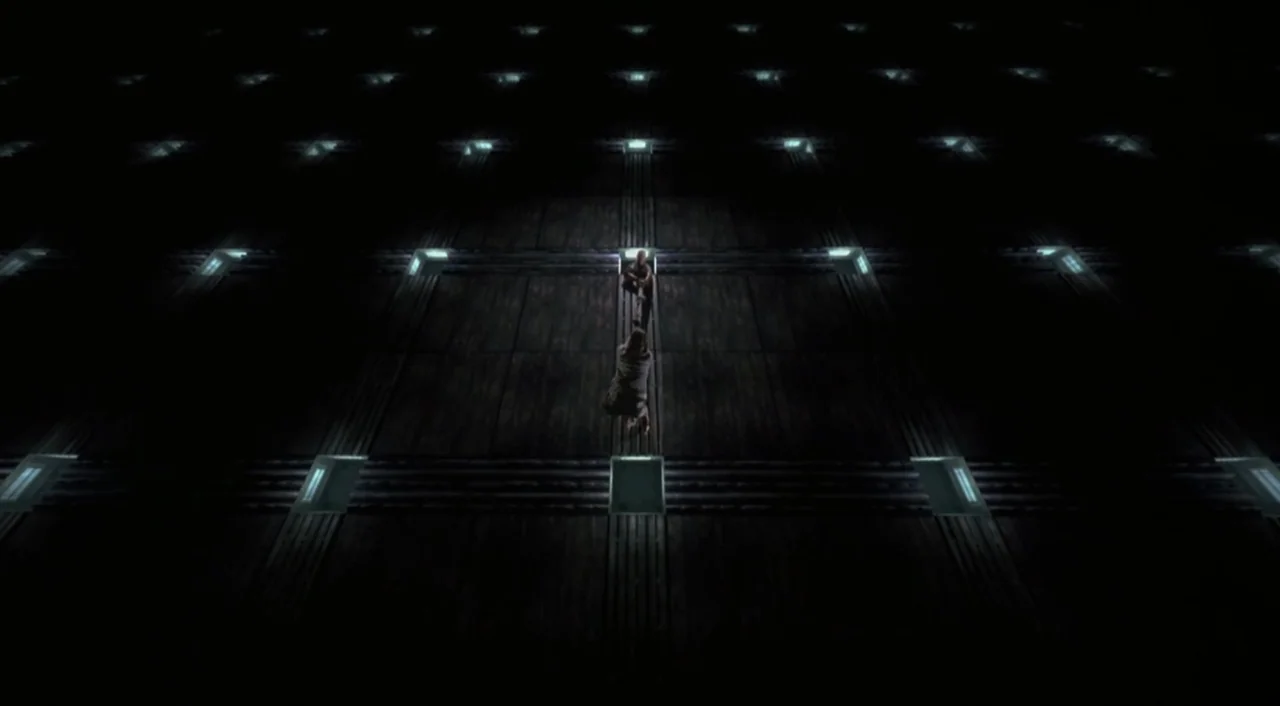 Cube (1997) movie still: wide — A vast, dark floor is composed of a repetitive grid of illuminated square panels. Two small human silhouettes are…