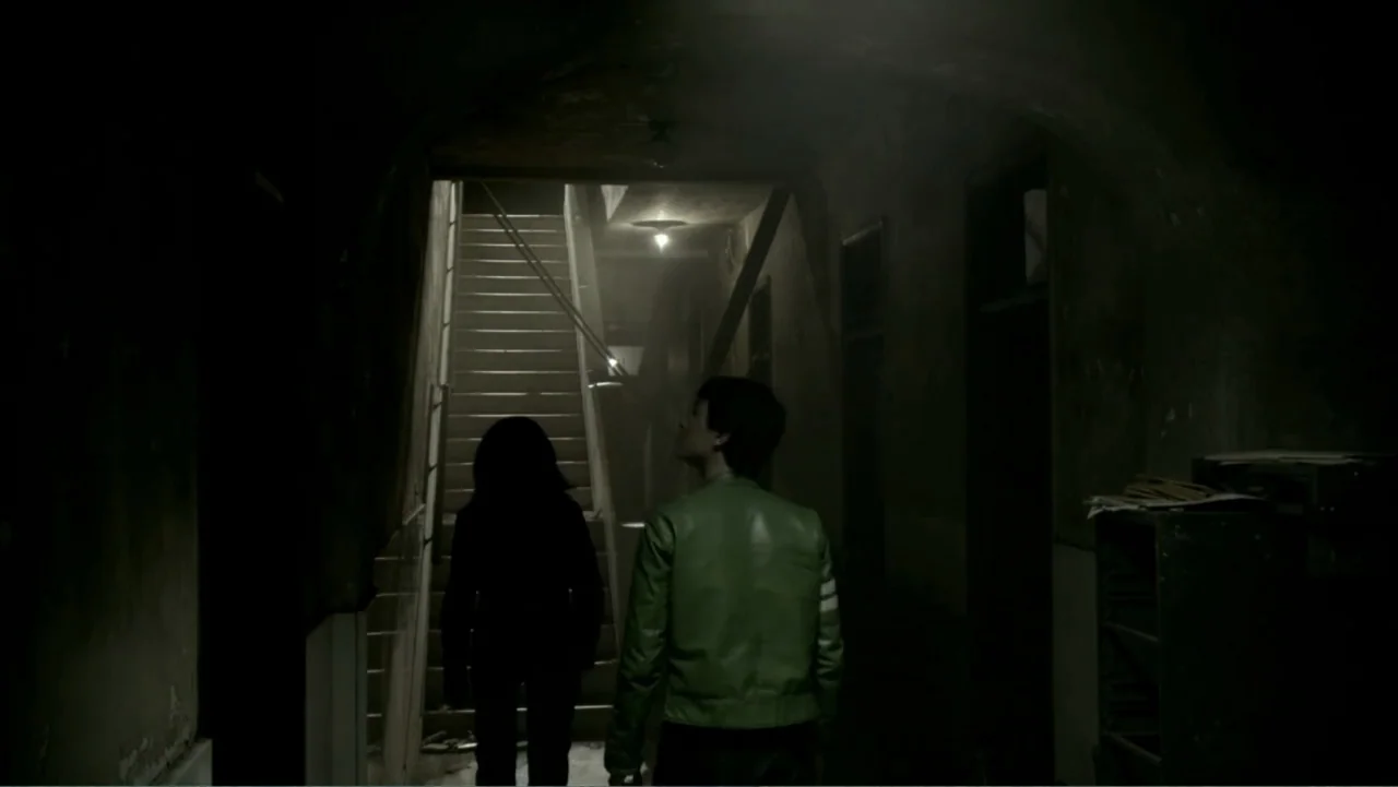 Ben 10: Race Against Time (2008) movie still: medium — A dimly lit interior stairwell with peeling walls and industrial overhead lighting. A man in…