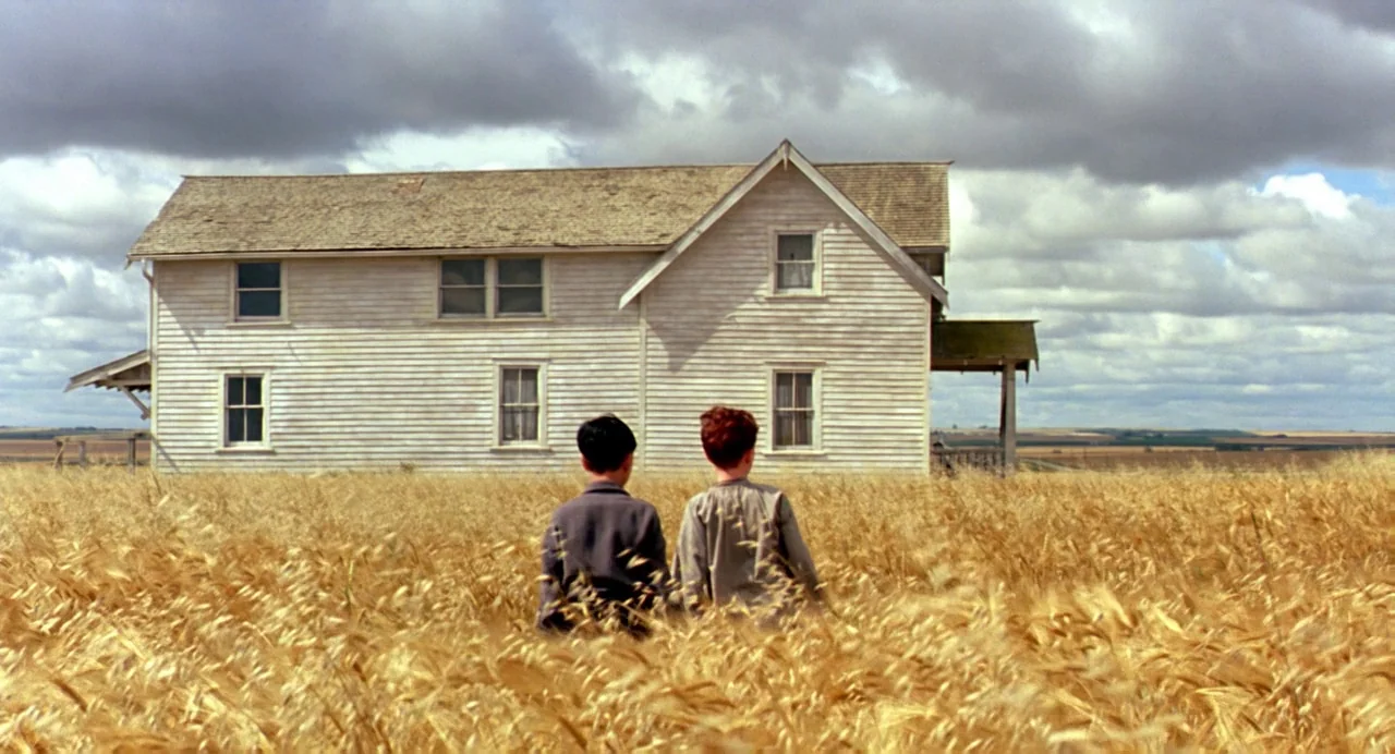 The Reflecting Skin (1990) movie still: wide — A vast field of mature golden wheat surrounds a solitary, weathered white farmhouse. Two young boys…