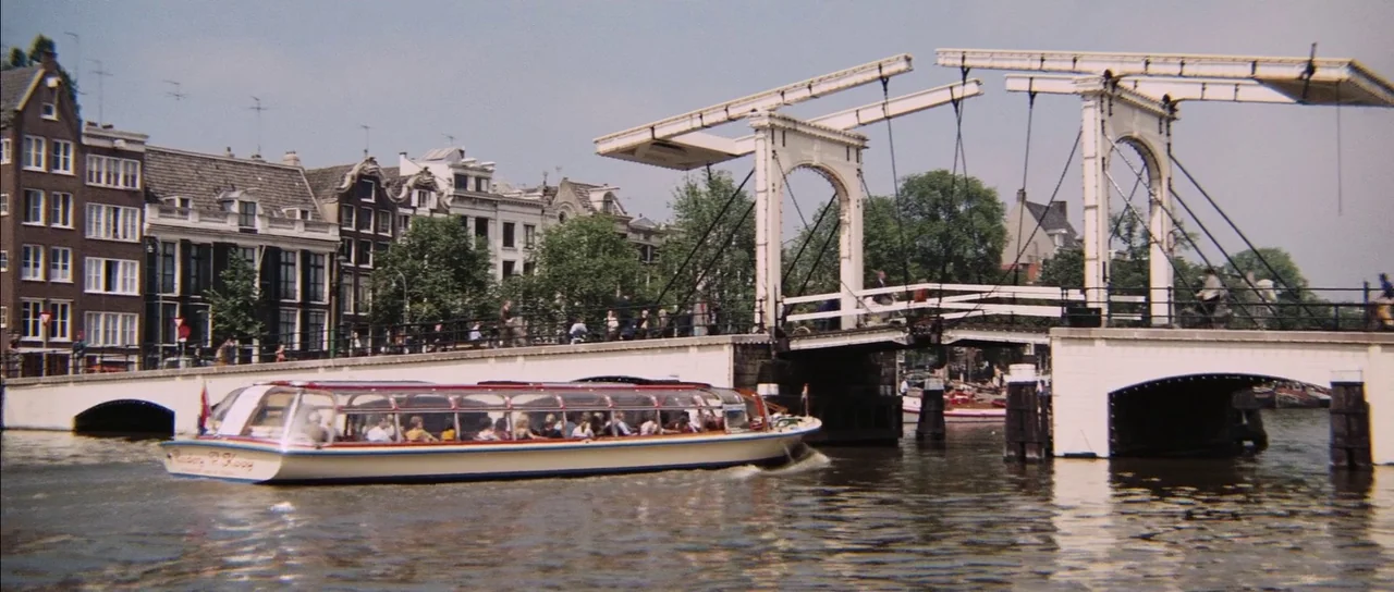 Diamonds Are Forever (1971) movie still: wide — A traditional Dutch canal in Amsterdam features a white historic drawbridge over the water. A…