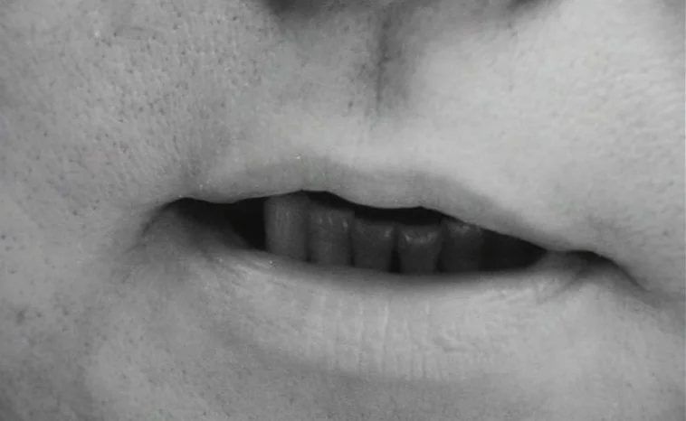 The Cremator (1969) movie still: closeup — An extreme close-up of a human mouth shows skin pores and lip texture. The mouth is parted slightly to…