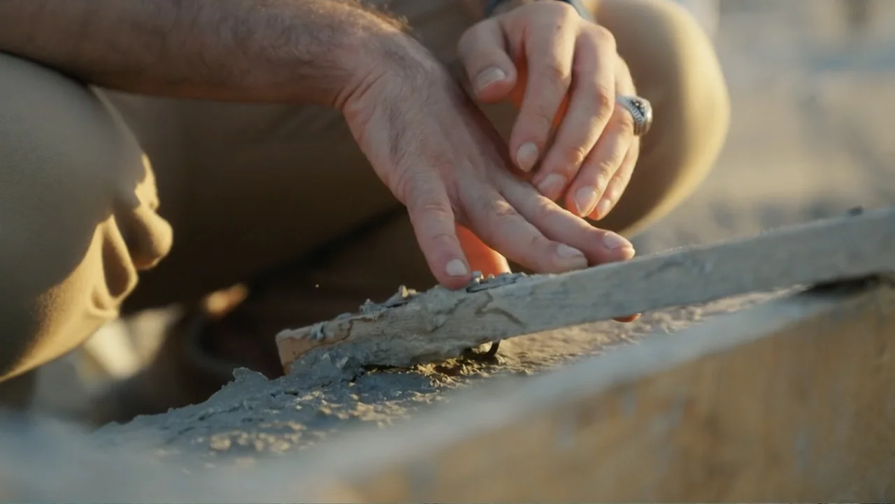 Death Without Mercy (2024) movie still: closeup — A construction environment at golden hour with rough concrete and dusty surfaces visible. Hands…