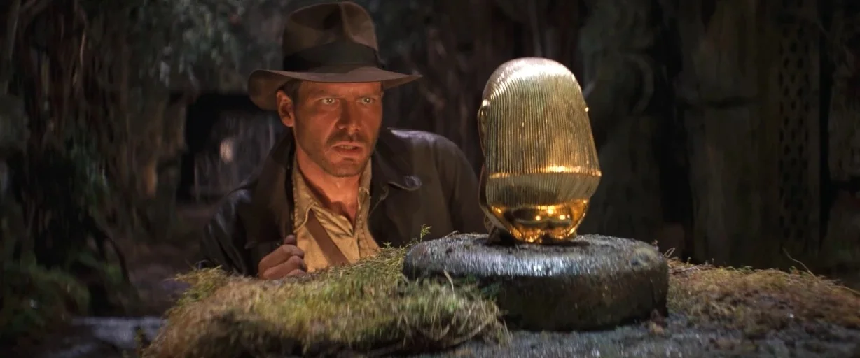 Indiana Jones and the Last Crusade (1989) movie still: medium — A dark stone chamber filled with mossy surfaces and ancient relics. An explorer…
