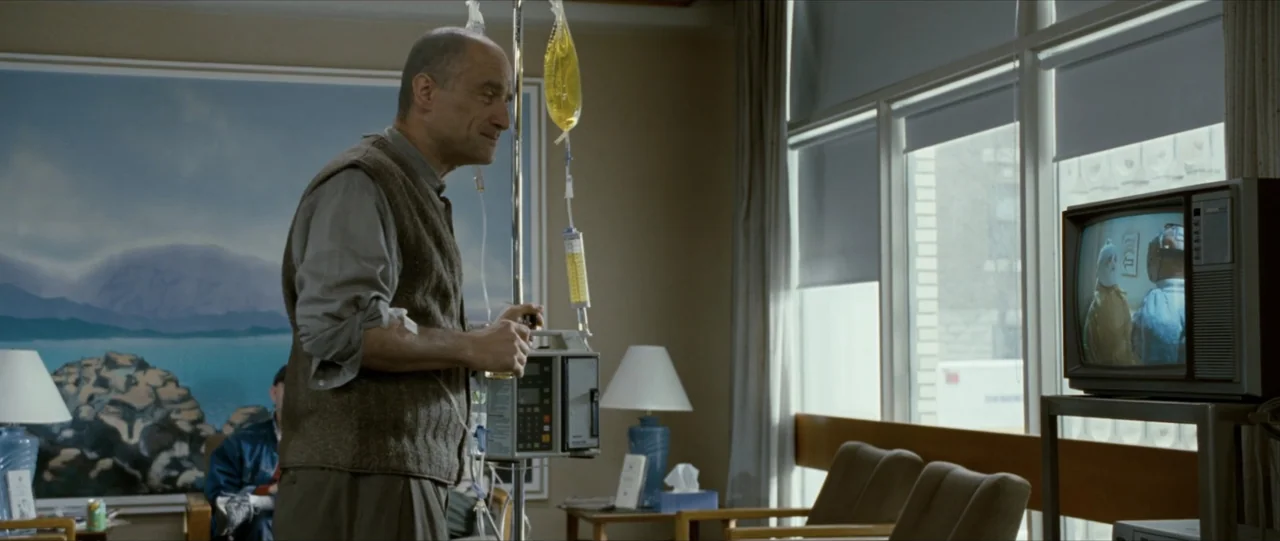 The Haunting in Connecticut (2009) movie still: medium — A quiet hospital waiting area contains blue cushioned chairs and a landscape print artwork.…