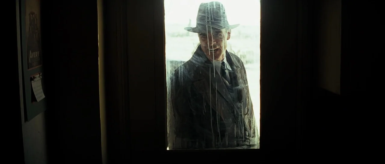 Changeling (2008) movie still: medium — A man stands behind a glass door featuring vertical streaks and smudges of grime. He gazes into the dark…