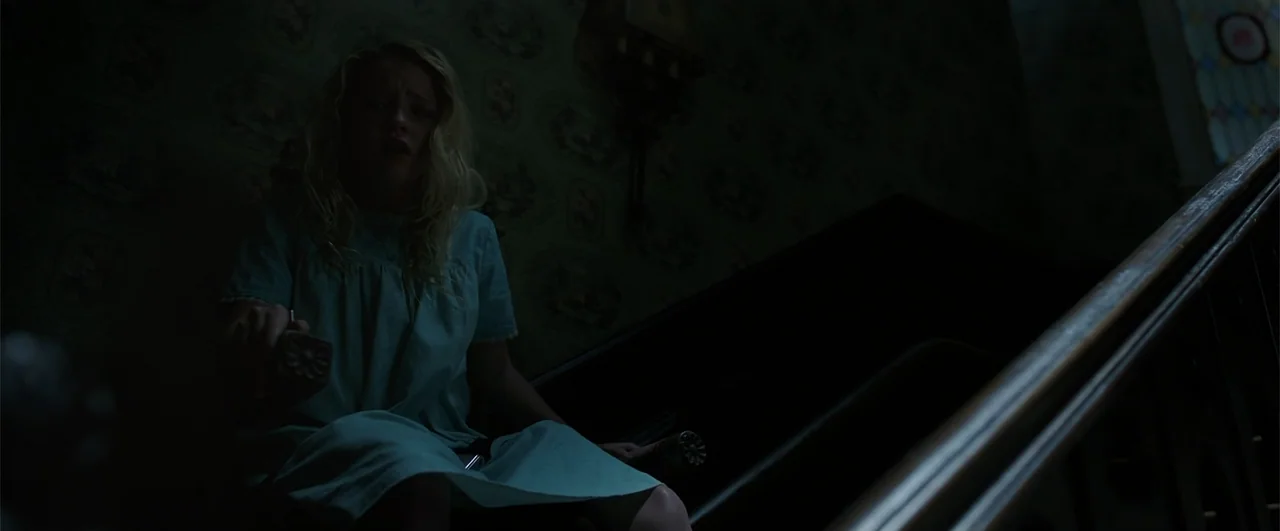 Annabelle: Creation (2017) movie still: medium — An interior staircase is decorated with dark, patterned vintage floral wallpaper. A young girl in a…