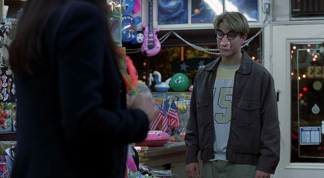 Good Will Hunting (1997) movie still: medium — A cluttered retail space contains shelves packed with various small toys and decorative items. A man…