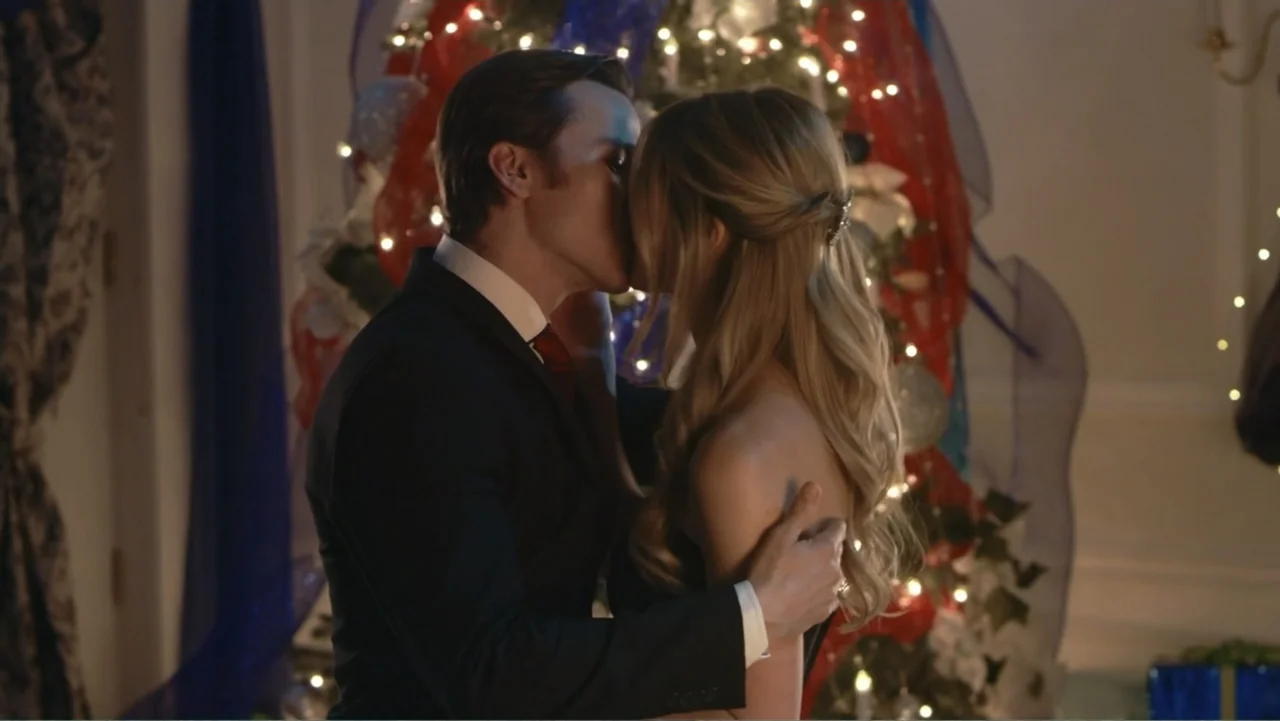 Driving Madeleine (2022) movie still: medium — An interior living room is decorated for the holidays with a lit Christmas tree. A man in a suit and…