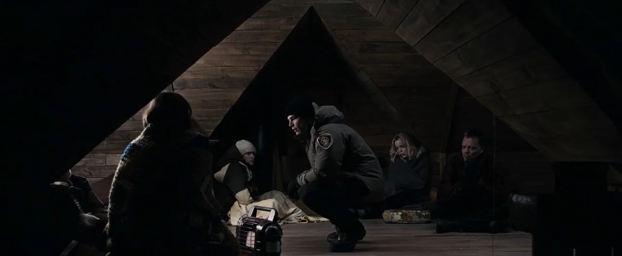 30 Days of Night (2007) movie still: wide — A dimly lit attic with sloping wooden walls and exposed rafters provides a cramped shelter. Several…