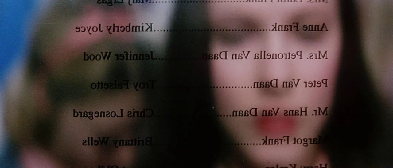 Pretty Persuasion (2005) movie still: closeup — A close-up shot shows a list of names superimposed over a blurred human face. The background…