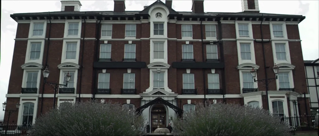 Kill List movie still: wide — A multi-story brick hotel with numerous symmetrical white-framed windows and a central entrance. Two large, rounded…