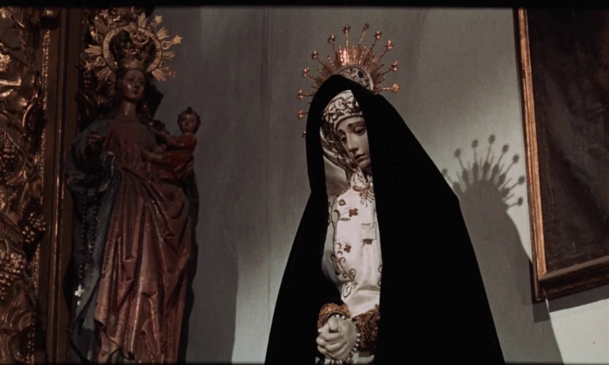 Tristana (1970) movie still: medium — A church interior with pale walls and golden decorative elements. A sculpted statue of the Virgin Mary stands…