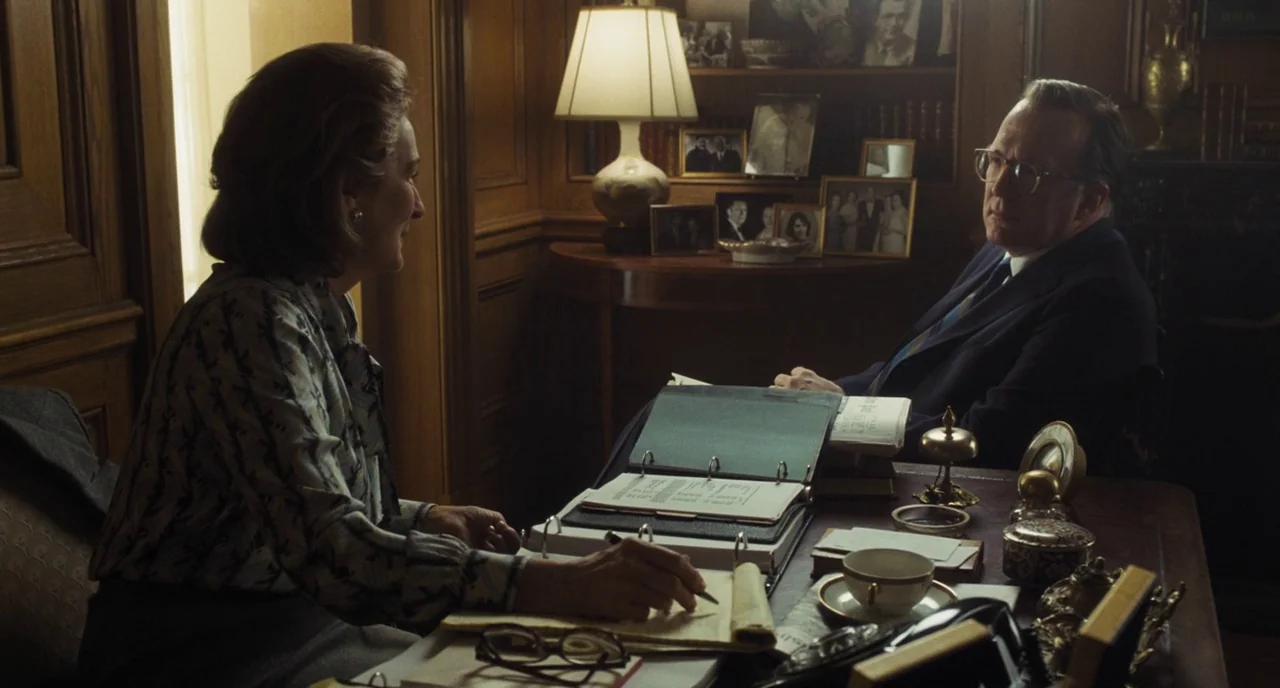 The Post (2017) movie still: medium — A wood-paneled room containing a desk cluttered with documents and personal framed photographs. A woman writes…