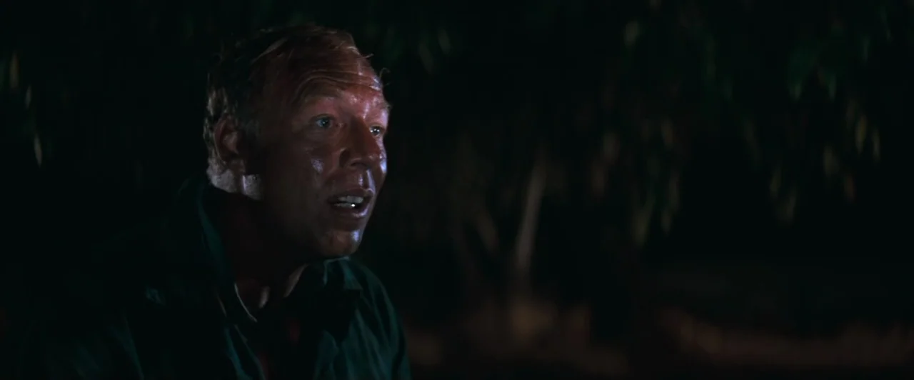 Cool Hand Luke (1967) movie still: closeup — A dark, nocturnal outdoor setting with blurred foliage visible behind a man. The man is positioned in…