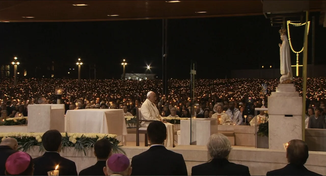 Pope Francis: A Man of His Word (2018) movie still: wide — A vast outdoor sanctuary at night illuminated by thousands of small individual candles.…