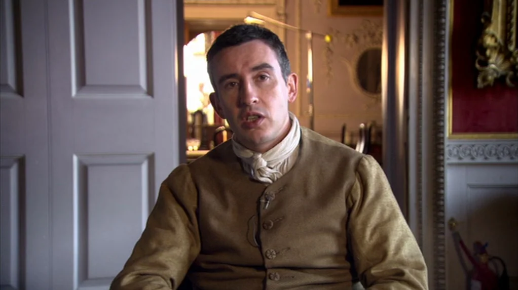 A Cock and Bull Story (2005) movie still: medium — A man stands in a room with ornate light-colored walls and paneling. He faces the camera directly…