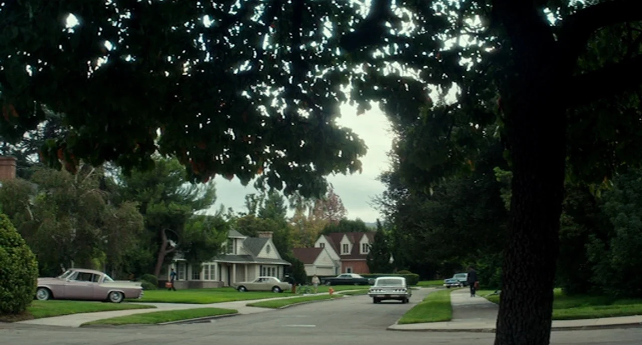Ouija: Origin of Evil (2016) movie still: wide — A quiet suburban residential street features several vintage American cars parked along the curb.…