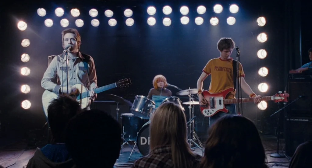 Scott Pilgrim Vs The World (2010) movie still: medium — A small club stage features a musical band backlit by a rectangle of bright lights. The band…