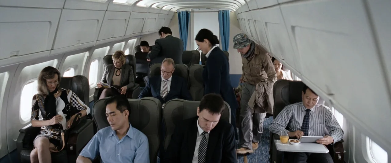 Hector and the Search for Happiness (2014) movie still: wide — The interior of a narrow-body passenger aircraft with rows of leather seats. Multiple…