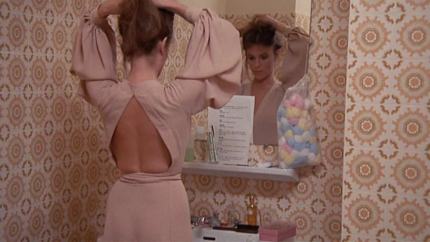 Day for Night (1973) movie still: medium — A bathroom features walls covered in patterned beige and brown vintage 1970s tile. A woman stands in…