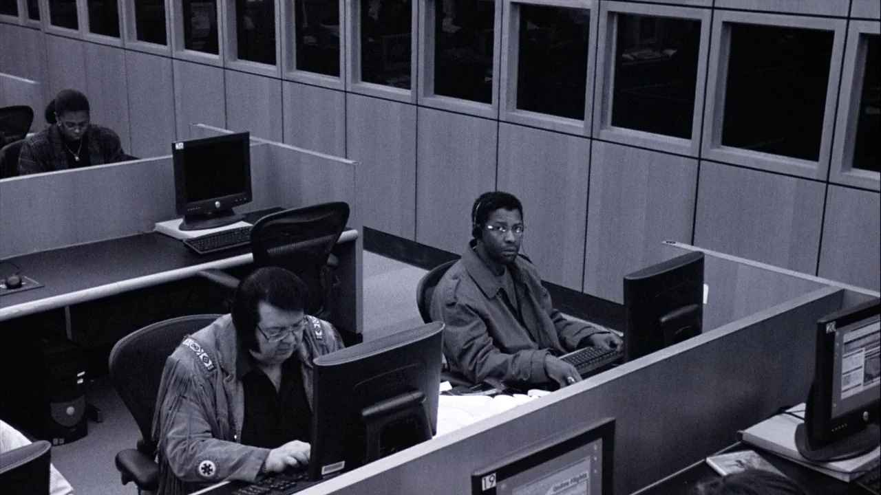 The Manchurian Candidate (2004) movie still: wide — A dense office floor is arranged with rows of grey cubicles and multiple computer terminals.…