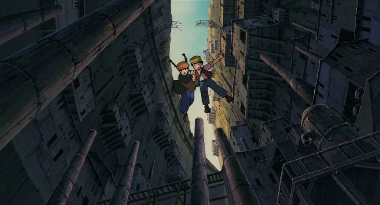 Castle in the Sky (1986) movie still: wide — A vertical city structure features dense, tall buildings with numerous protruding metal pipes. Two…