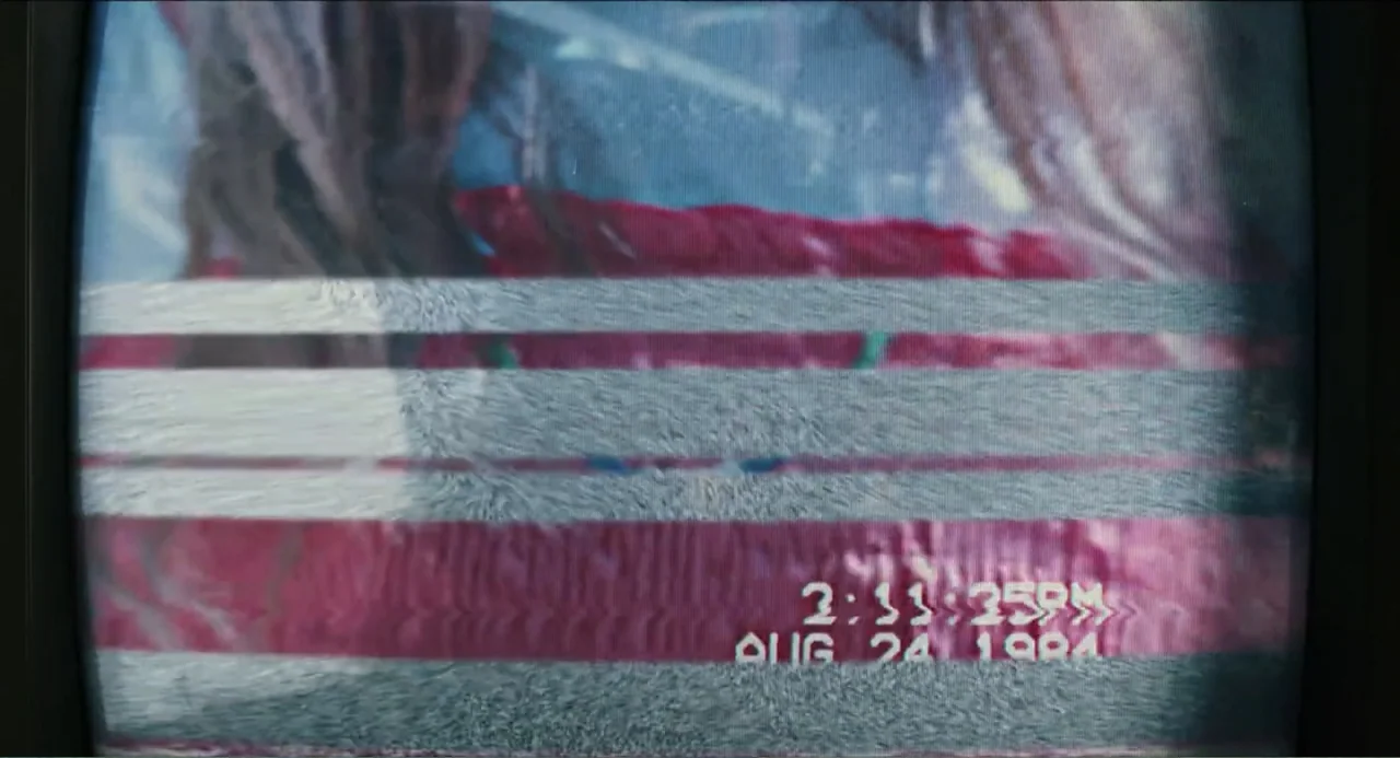Haunter (2013) movie still: closeup — A low-resolution cathode ray tube screen displays distorted analog video content with visual static. A digital…