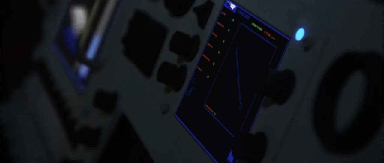 Astronaut: The Last Push (2012) movie still: closeup — A close-up view of a dark electronic control panel featuring illuminated display screens and…