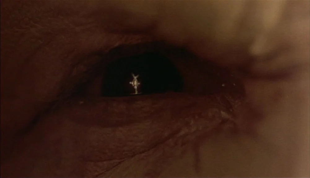 Bram Stoker’s Dracula (1992) movie still: closeup — An extreme close-up of a human eye with visible skin texture around the eyelid. A tiny figure is…