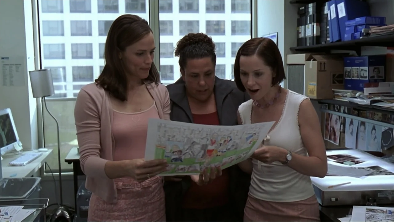 13 Going on 30 (2004) movie still: medium — Three women stand in a brightly lit, professional workspace with shelves filled with media files. They…