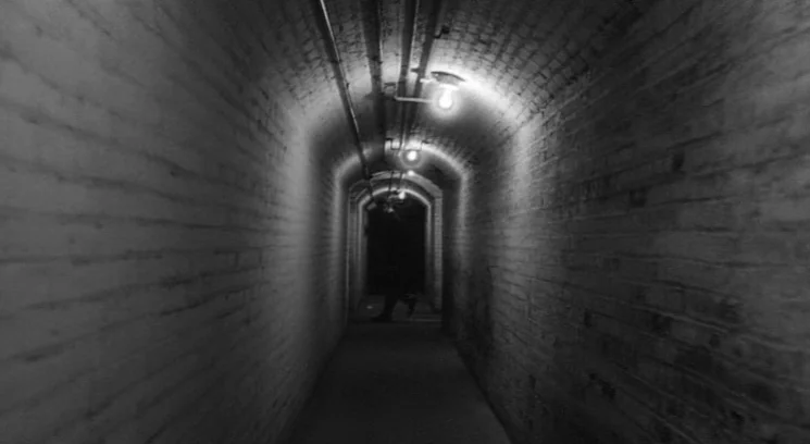 Raging Bull (1980) movie still: establishing — A long underground arched brick tunnel is illuminated by a row of exposed lightbulbs. The far end of…