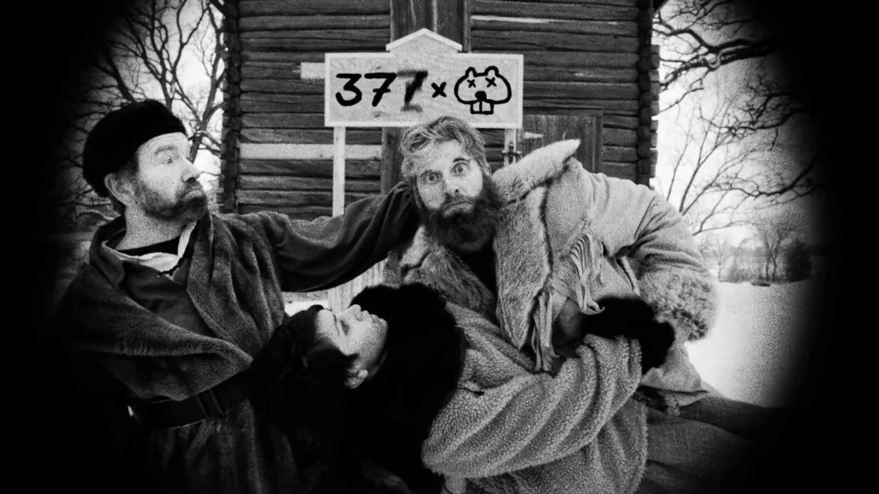 Hundreds of Beavers (2022) movie still: medium — A rustic log cabin sits in a snowy landscape with a hand-painted wooden sign. Two men in thick…