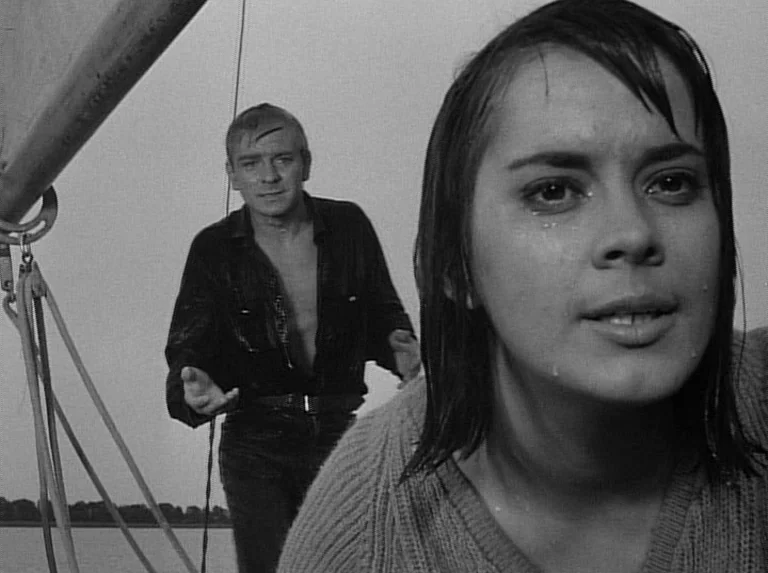 Knife In The Water (1962) movie still: closeup — A wet woman and man occupy the deck of a sailboat during the day. The woman is in the foreground…